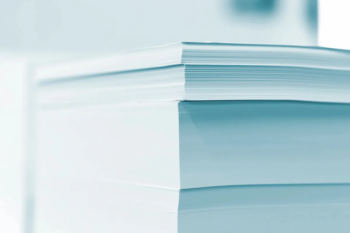 Close-up of a neat stack of white paper tinted blue-green